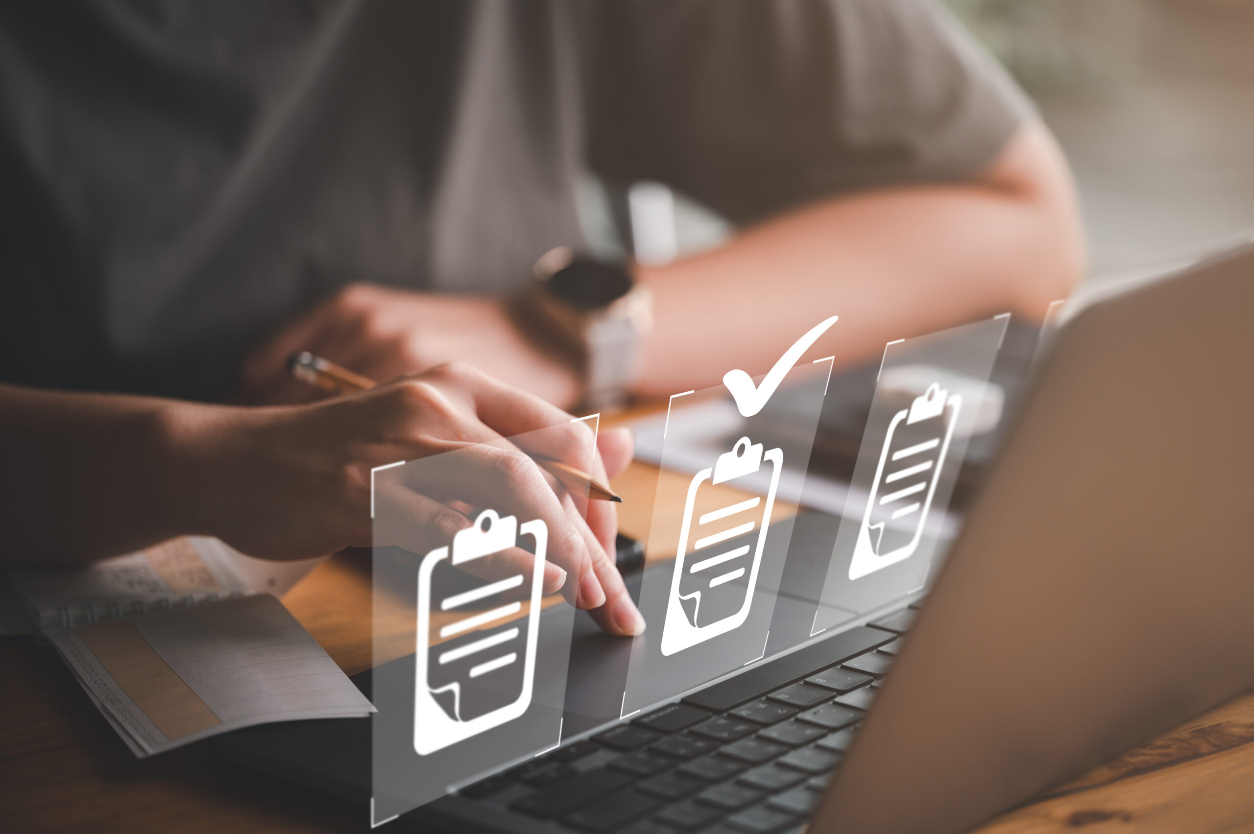 Hand using laptop computer with virtual screen and document for online approve paperless quality assurance and ERP management concept.